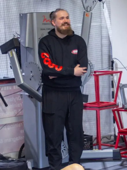 Coach Craig, smiling, arms crossed, in a black F45 hoodie
