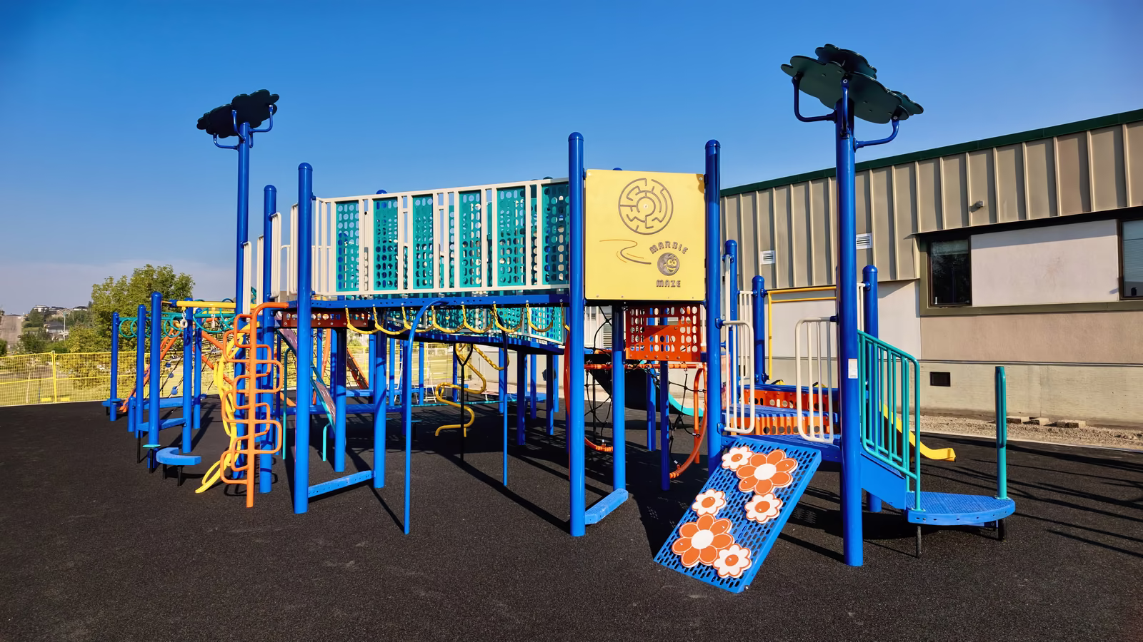 The play tower seen from the school side, with a large yellow marble maze panel mounted on it