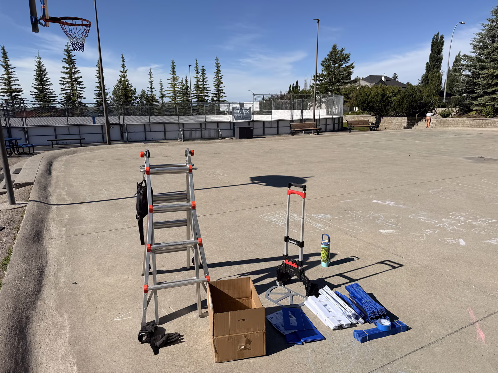 Ladder, supplies and rolls of tape laid out on the empty court at the start of the day