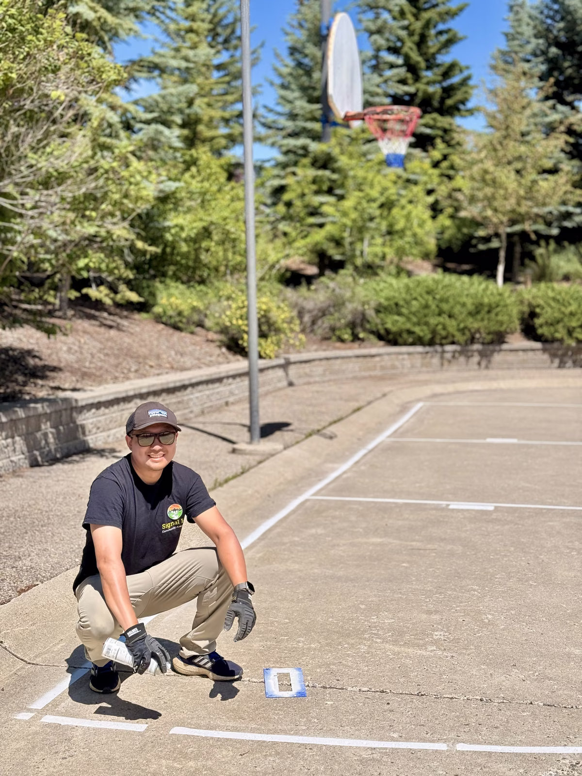 The finished basketball court with fresh white lines, and volunteers at work on the rink boards